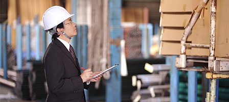 Engineer inspecting warehouse inventory with clipboard
