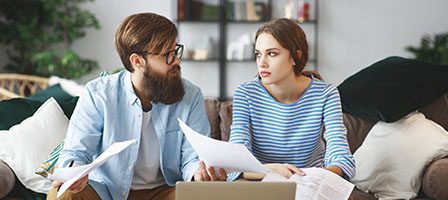 Two people analyzing paperwork at home