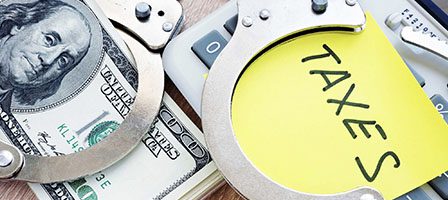 Money, handcuffs, and taxes concept