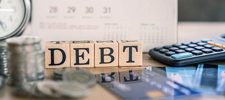 Debt concept with calculator and coins