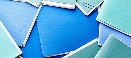 Colorful folders scattered on blue background