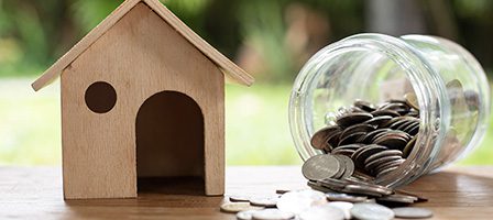 Savings concept with house and jar