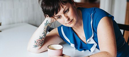 Woman with tattoos looking contemplative
