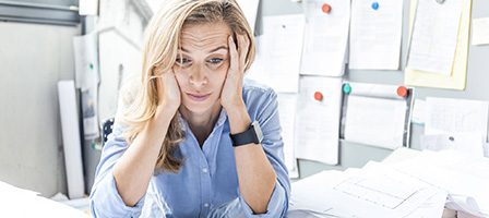 Stressed woman at cluttered desk