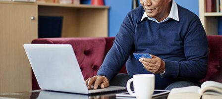 Senior using laptop in living room