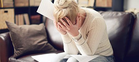 Stressed woman holding her head in hands