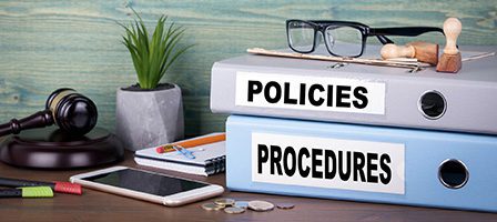 Office desk with policies and procedures folders