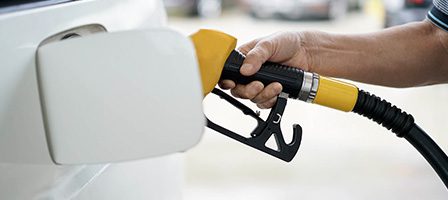 Fuel pump nozzle refueling white car