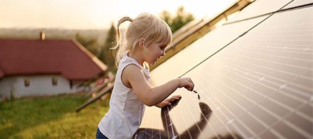 Child touching solar panel at sunset