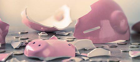 Broken piggy bank with scattered coins