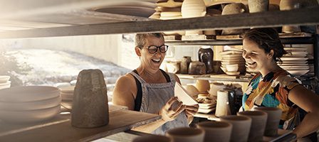 Smiling women surrounded by pottery creations