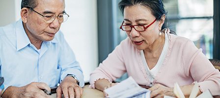Older adults reading paperwork indoors