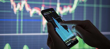 Person analyzing stock data on smartphone