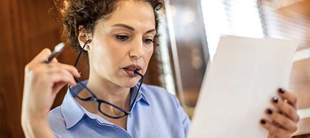 Person analyzing paperwork indoors
