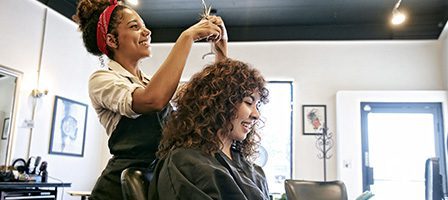 Hairdresser styling client's curly hair