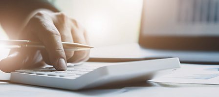 Person calculating finances on desk