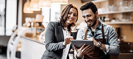Cafe owner and customer discussing tablet