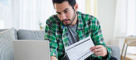 Man working on laptop with document