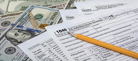 IRS 1040 form with cash and pencil