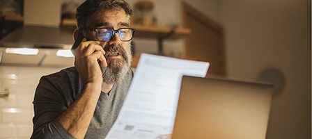 Bearded man reading papers at desk