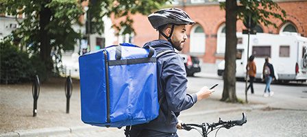 Bicycle courier with blue delivery bag