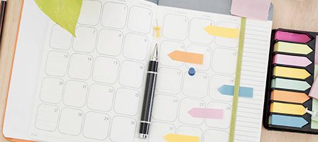 Desk planner featuring colorful tabs and pen