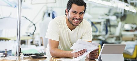 Man smiling while holding documents
