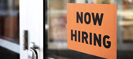 Now hiring sign on glass door