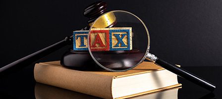 Magnifying glass over tax blocks