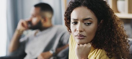 Thoughtful woman, man sitting behind her