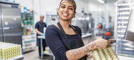 Female employee holding product in production area