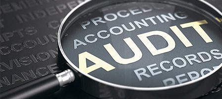 Magnifying glass over the word "Audit