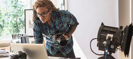 Creative professional with camera and laptop