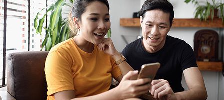 Happy pair browsing on smartphone together