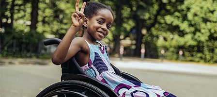Girl in wheelchair smiling outdoors