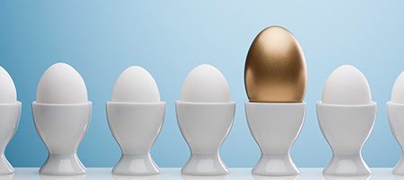 Unique golden egg in row of eggs