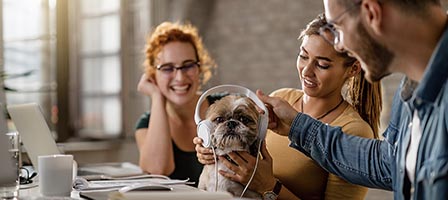Friends enjoying time with dog at work