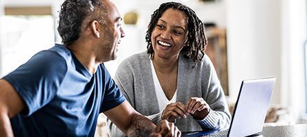 Man and woman smiling at laptop