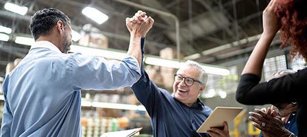 Colleagues cheer in a warehouse