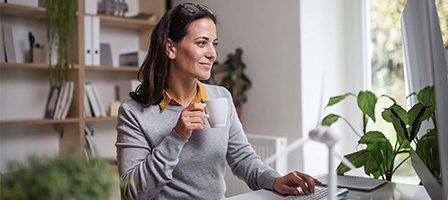 Woman enjoying coffee while working remotely