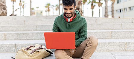 Student with laptop and backpack outside