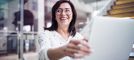 Happy woman using laptop indoors