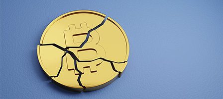 Cracked Bitcoin coin on blue background