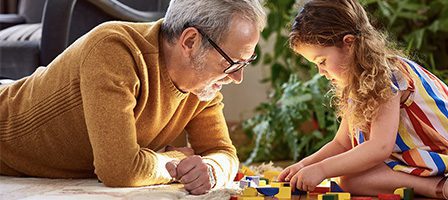 Grandfather and granddaughter playing with blocks