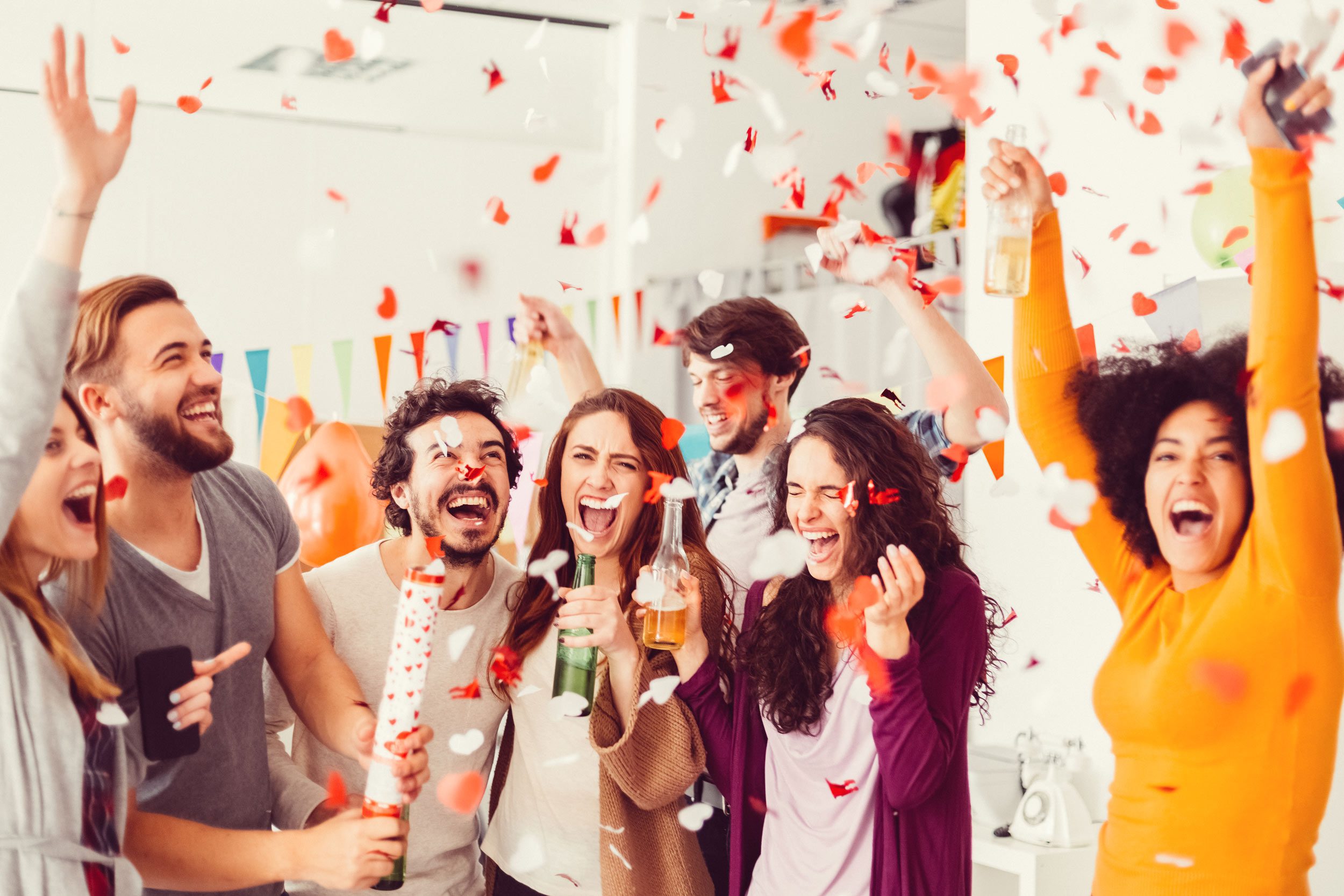 Group celebrating with confetti and drinks