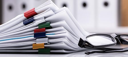 Glasses beside organized documents