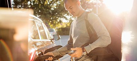Sunlit fuel station with man filling car