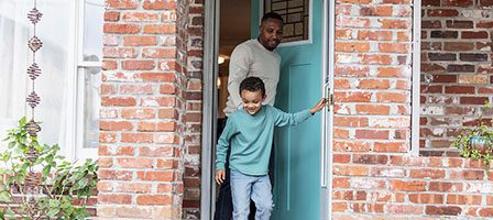 Father and son exiting blue door