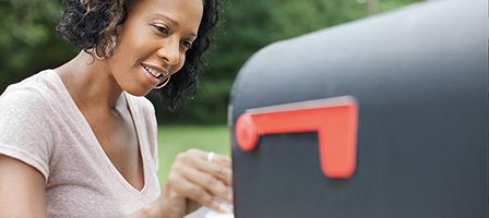 Woman opening mailbox outdoors