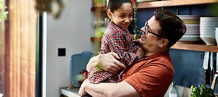 Father and daughter smiling in kitchen